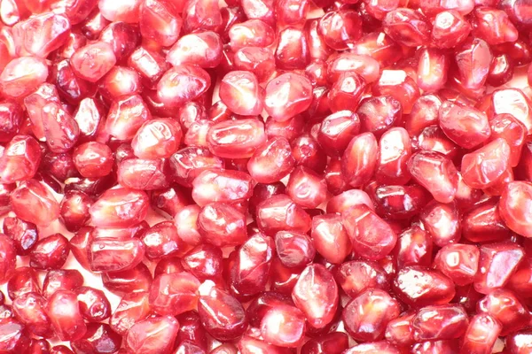 Macro photo of juicy, ripe pomegranate seeds, bright burgundy food background