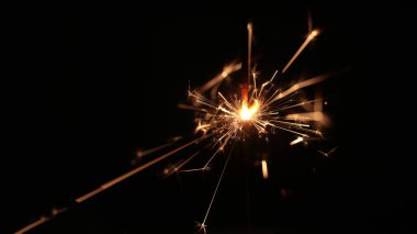 Şenlikli maytap ve bir sürü kıvılcım saçan makro fotoğraf arka planda Noel ve Yeni Yıl