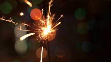 Şenlikli maytap ve bir sürü kıvılcım saçan makro fotoğraf arka planda Noel ve Yeni Yıl