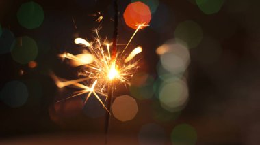 Şenlikli maytap ve bir sürü kıvılcım saçan makro fotoğraf arka planda Noel ve Yeni Yıl