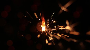 Şenlikli maytap ve bir sürü kıvılcım saçan makro fotoğraf arka planda Noel ve Yeni Yıl