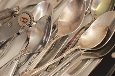 Günlük kullanım için temiz mutfak aletleri, beyaz masa arkasındaki boş tabaklar.