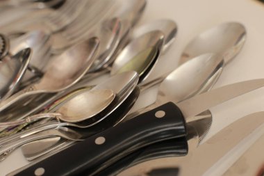 Günlük kullanım için temiz mutfak aletleri, beyaz masa arkasındaki boş tabaklar.