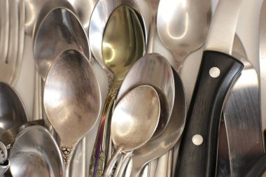 Günlük kullanım için temiz mutfak aletleri, beyaz masa arkasındaki boş tabaklar.