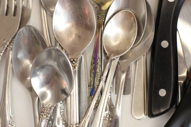 Günlük kullanım için temiz mutfak aletleri, beyaz masa arkasındaki boş tabaklar.