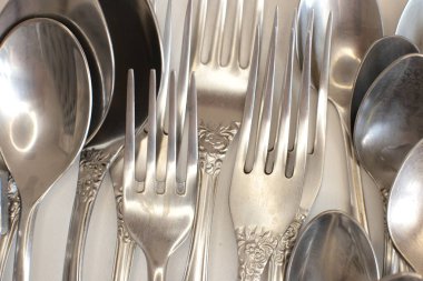 Günlük kullanım için temiz mutfak aletleri, beyaz masa arkasındaki boş tabaklar.