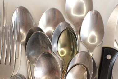 Günlük kullanım için temiz mutfak aletleri, beyaz masa arkasındaki boş tabaklar.