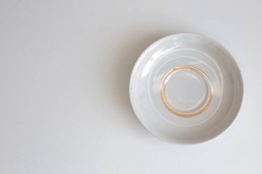 Günlük kullanım için temiz mutfak aletleri, beyaz masa arkasındaki boş tabaklar.