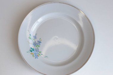 Günlük kullanım için temiz mutfak aletleri, beyaz masa arkasındaki boş tabaklar.