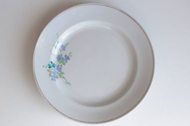 Günlük kullanım için temiz mutfak aletleri, beyaz masa arkasındaki boş tabaklar.