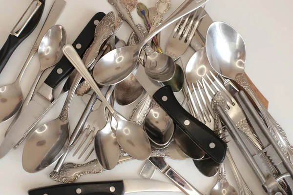 Günlük kullanım için temiz mutfak aletleri, beyaz masa arkasındaki boş tabaklar.