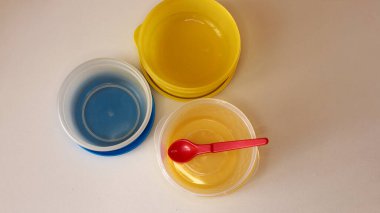 Beyaz masa arkasında boş plastik yemek takımı