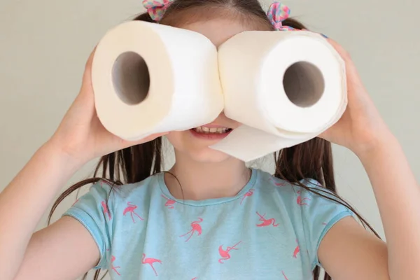 Tuvalet kağıdı taşıyan komik genç bir kız tuvalet kağıdı karantinasında fotoğraf şakası yapıyor.