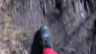 Lastik çizmeli bir adamın ayakları çamurda yürür.