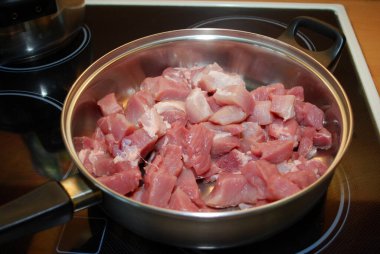 Kızartma tavasında dilimlenmiş çiğ domuz jambonu var. Et tabağı-domuz yahnisi hazırlığı. Ev yemeği..