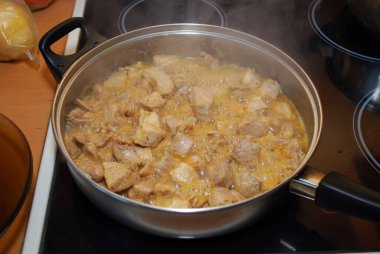 Dilimlenmiş domuz eti parçaları soya sosunda haşlanır ve kendi suları kızartma tavasında pişirilir. Et tabağı-domuz yahnisi hazırlığı. Ev yemeği..