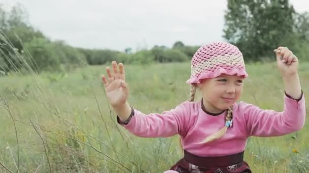 Маленькая девочка играет на поле — стоковое видео