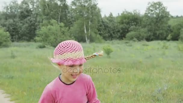 En liten flicka går över hela fältet — Stockvideo