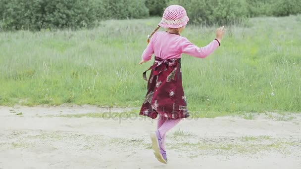 Маленька дівчинка біжить по полю — стокове відео