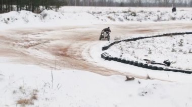 adam kışın bir karla kaplı yolda bir Atv sürme