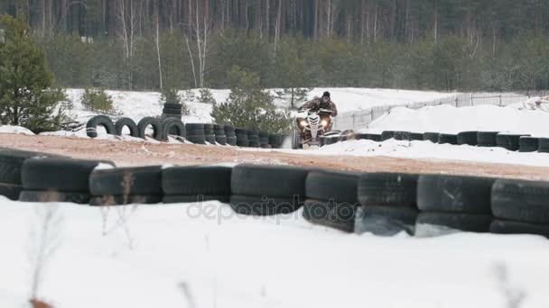 Killen ridning en Atv på en snötäckt väg på vintern — Stockvideo