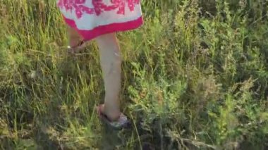 tarlada çalışan kırmızı desenleri ile beyaz bir sundress, küçük kız