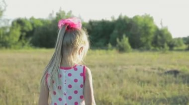 tarlada çalışan kırmızı desenleri ile beyaz bir sundress, küçük kız