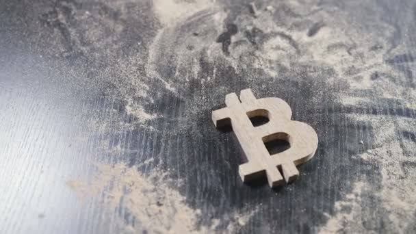Symbolen för trä bitcoin ligger på ett dammigt bord — Stockvideo
