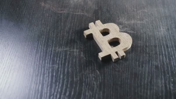 Дерев'яні bitcoin символ лежить на курній таблиці — стокове відео