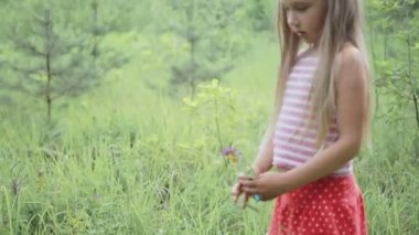 küçük kız ormanın yakınındaki açıklıkta oynamaktan