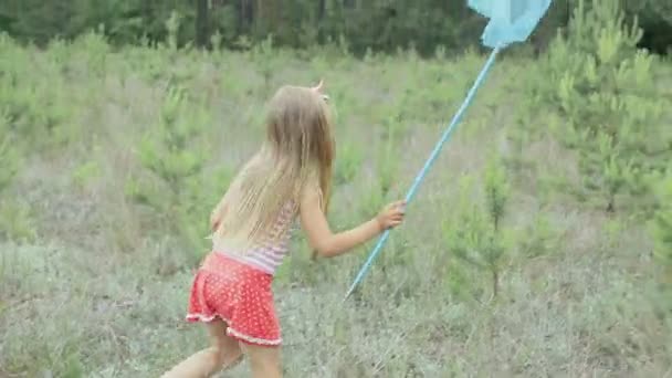 Malá holčička hraje na mýtině nedaleko lesa — Stock video