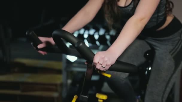 La chica se dedica a la bicicleta estática — Vídeos de Stock