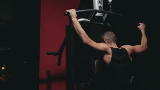 Парень тренирует плечи на тренажере — стоковое видео