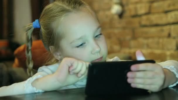 Happy babymeisje met smartphone in café — Stockvideo