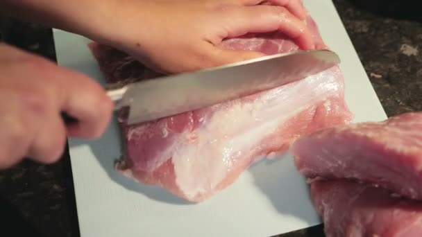 Mulher corta carne na cozinha — Vídeo de Stock