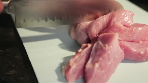 Frau schneidet Fleisch in der Küche — Stockvideo