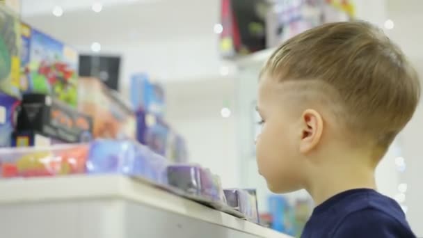 Chlapec se dívá na okno s hračkami — Stock video