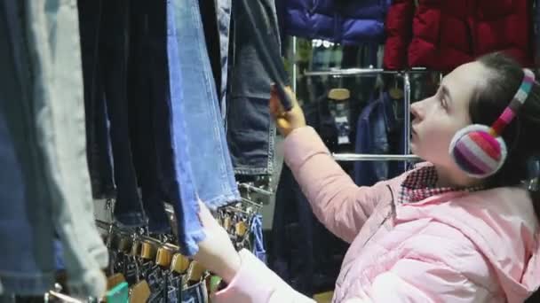 Mulher escolhe calças na loja — Vídeo de Stock