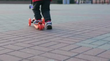 neşeli küçük çocuk bir scooter sürme