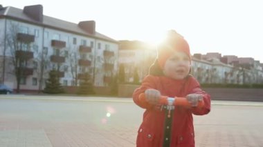 neşeli küçük çocuk bir scooter sürme