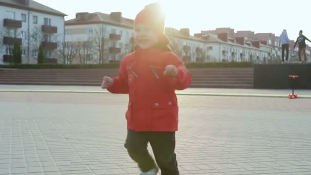Fröhlicher kleiner Junge auf einem Motorroller — Stockvideo