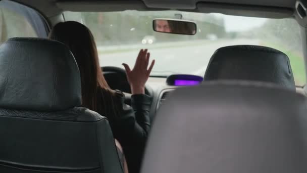 Jeune femme aux cheveux bruns frappe au volant d'une voiture cassée — Video