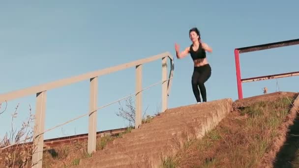 Joven bastante deportista se dedica a la aptitud en la naturaleza. La chica realiza ejercicios fuera de la ciudad. Steadicam tiro — Vídeos de Stock