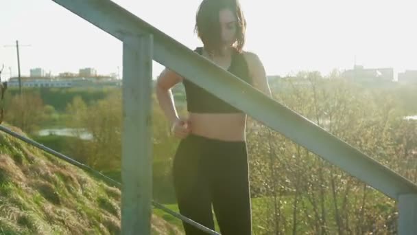 Joven bastante deportista se dedica a la aptitud en la naturaleza. La chica realiza ejercicios fuera de la ciudad. Steadicam tiro — Vídeo de stock