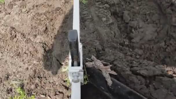 De lier trekt de kabel waarmee de ploeg is verbonden. Ploegen land op de boerderij. Man biedt de grond met een ploeg — Stockvideo