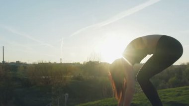 Genç sevimli kız akşam şehir arka plan üzerinde jimnastik yapıyor