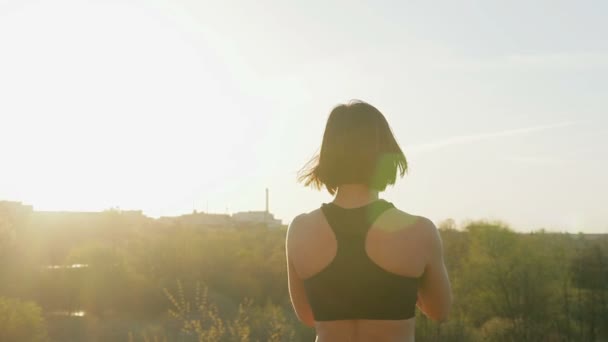 Nuori söpö tyttö tekee voimistelu auringonlaskun aikaan . — kuvapankkivideo