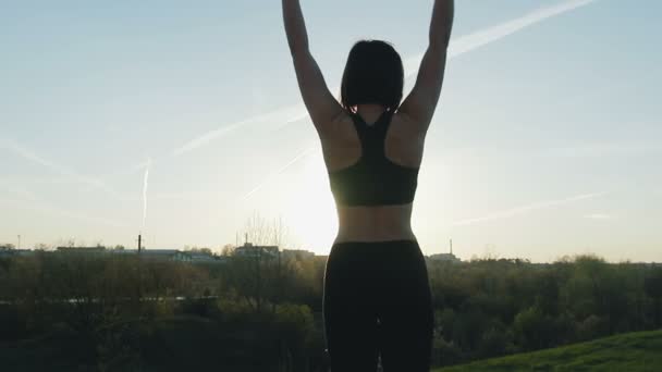 Roztomilá dívka dělá gymnastiku na pozadí večerní město — Stock video