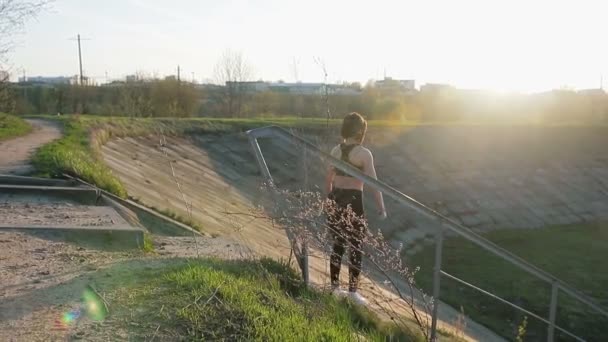 Joven linda chica haciendo ejercicios con sus manos en las escaleras — Vídeos de Stock