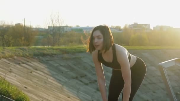 Jovem menina bonito fazendo exercícios com as mãos nas escadas — Vídeo de Stock